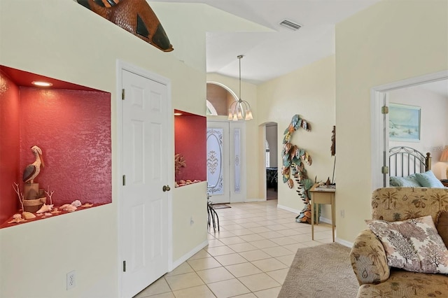 foyer featuring light tile patterned floors and an inviting chandelier