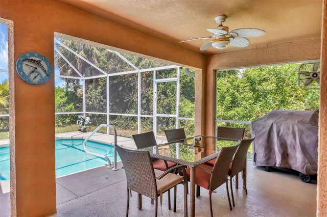 view of swimming pool featuring a grill, a patio, ceiling fan, and glass enclosure