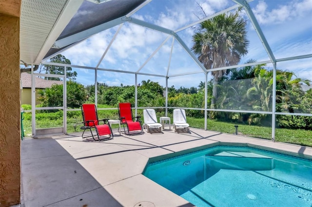 view of pool with glass enclosure and a patio area