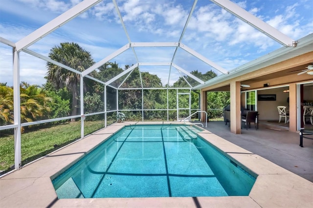 view of swimming pool featuring ceiling fan, glass enclosure, and a patio area