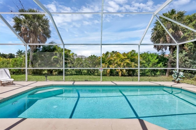 view of swimming pool featuring glass enclosure