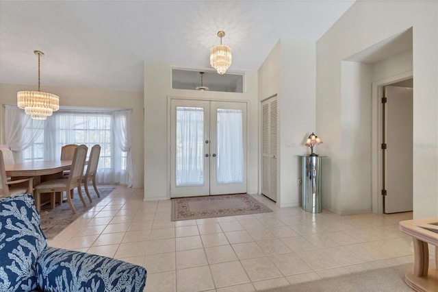 entryway with a notable chandelier, light tile patterned floors, and french doors