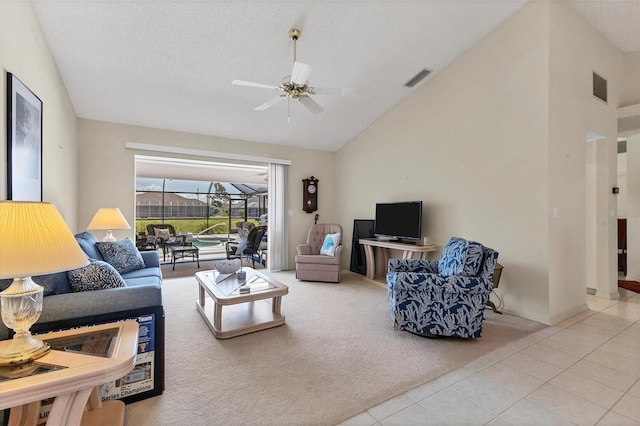 living room with a textured ceiling, vaulted ceiling, ceiling fan, and carpet flooring