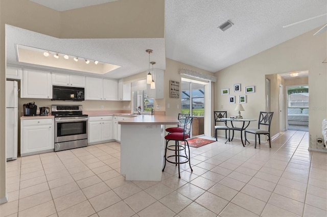 kitchen with light tile patterned floors, white cabinetry, plenty of natural light, white refrigerator, and stainless steel electric stove