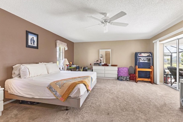 bedroom with a textured ceiling, access to outside, ceiling fan, and carpet flooring