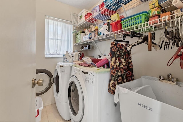 laundry room with light tile patterned flooring, sink, and washing machine and dryer