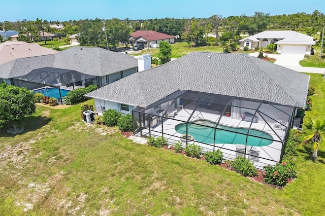 view of swimming pool with central AC unit, a patio area, glass enclosure, and a lawn