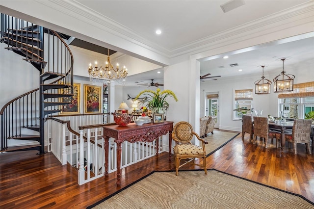 interior space with hardwood / wood-style flooring, crown molding, and ceiling fan with notable chandelier