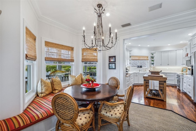 dining area featuring a notable chandelier, wood-type flooring, and ornamental molding