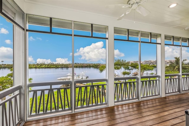 unfurnished sunroom featuring a water view and ceiling fan