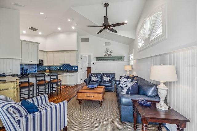 living room featuring ceiling fan, lofted ceiling, and sink