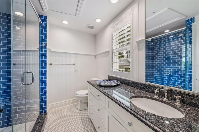 bathroom with tile patterned flooring, vanity, an enclosed shower, and toilet