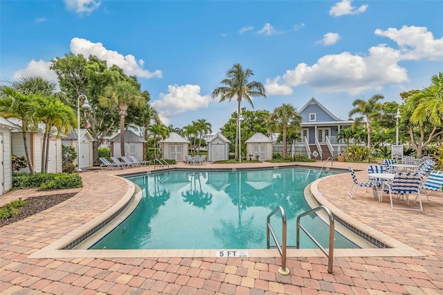 view of pool featuring a storage shed and a patio area