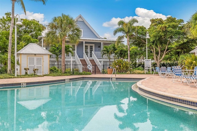 view of swimming pool with a shed and a patio