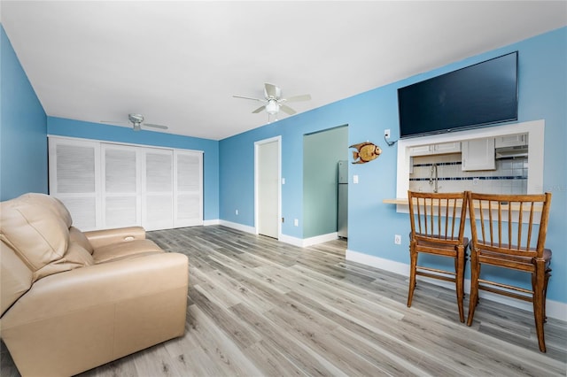 living room featuring ceiling fan and light hardwood / wood-style floors