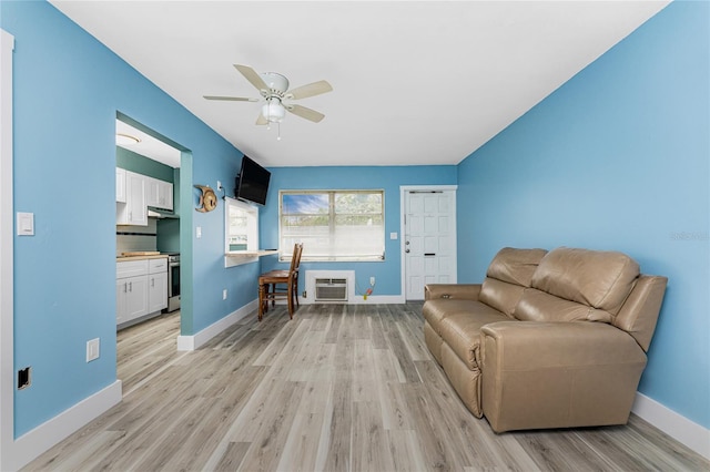 living area featuring ceiling fan, light hardwood / wood-style flooring, and a wall mounted air conditioner