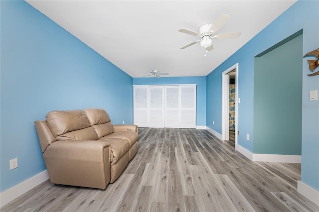 living area with ceiling fan and light wood-type flooring