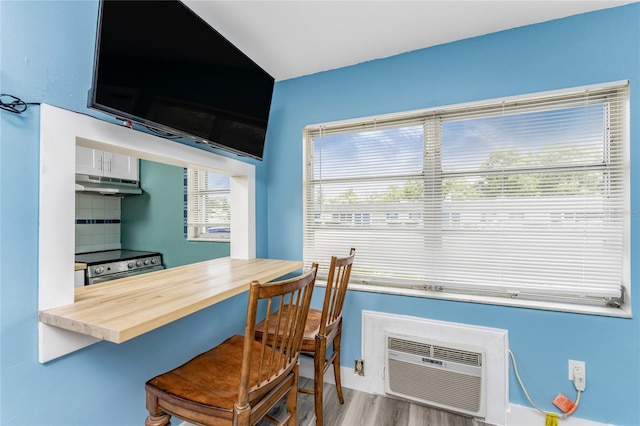 dining room featuring a wall mounted AC and light hardwood / wood-style floors