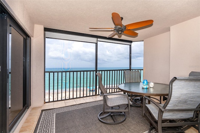 sunroom featuring a water view, a healthy amount of sunlight, and ceiling fan