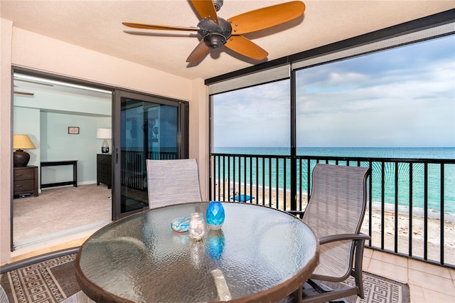 sunroom / solarium featuring a water view and ceiling fan