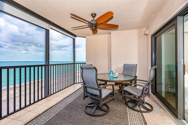 sunroom / solarium with a water view and ceiling fan