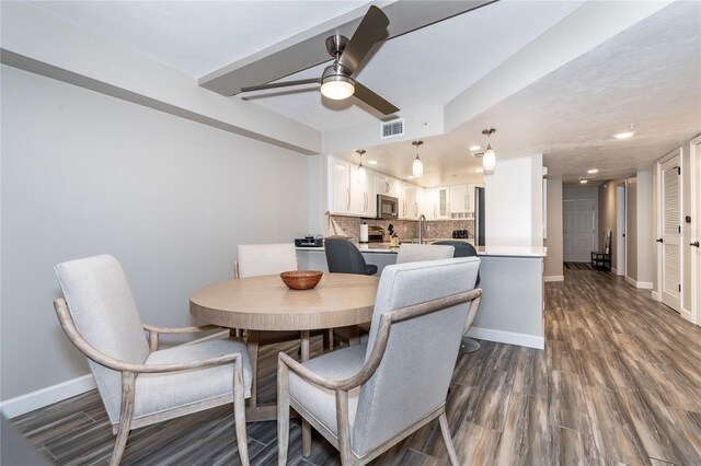 dining space with hardwood / wood-style floors and ceiling fan