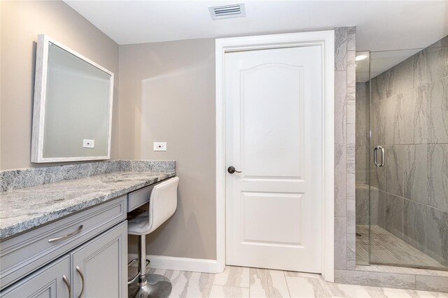 bathroom with tile patterned floors, vanity, and a shower with door