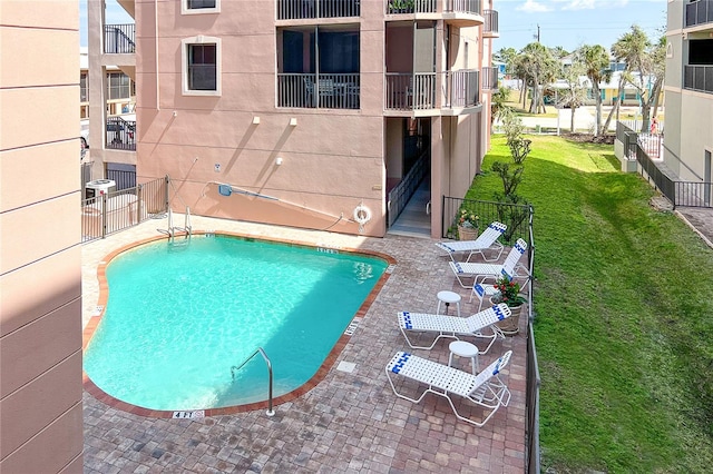 view of swimming pool featuring a patio area and a lawn