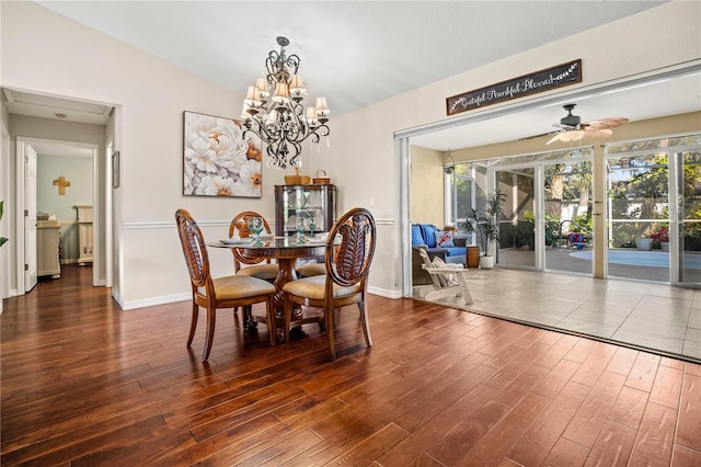 dining space with ceiling fan with notable chandelier, dark wood-type flooring, and lofted ceiling