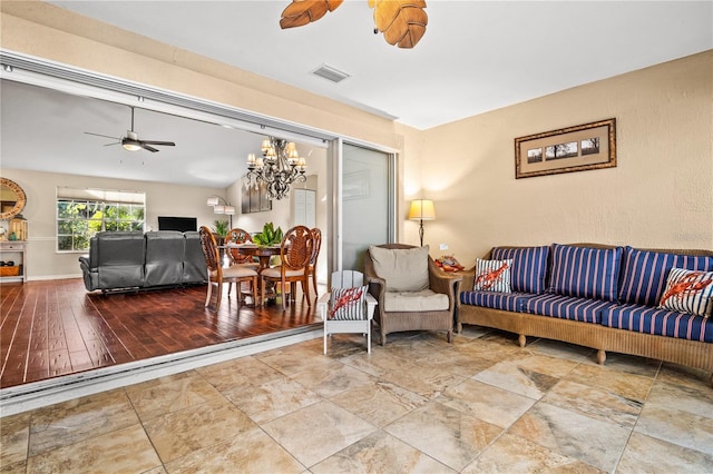 living room featuring ceiling fan with notable chandelier and hardwood / wood-style floors