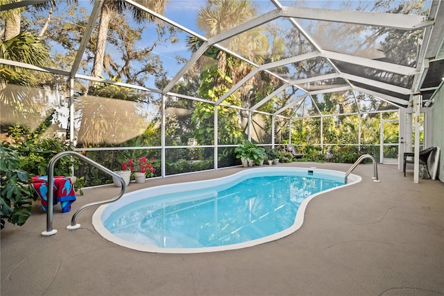 view of pool with a patio and glass enclosure