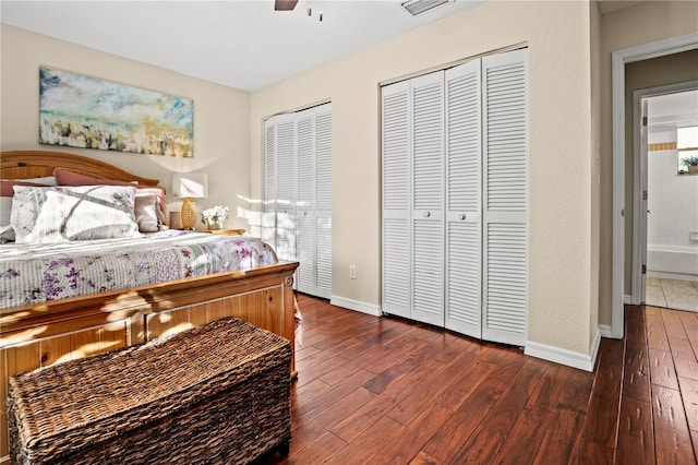 bedroom featuring multiple closets, ceiling fan, and dark hardwood / wood-style floors