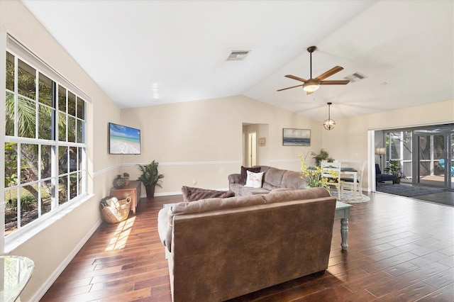 living area with baseboards, visible vents, ceiling fan, dark wood-type flooring, and vaulted ceiling