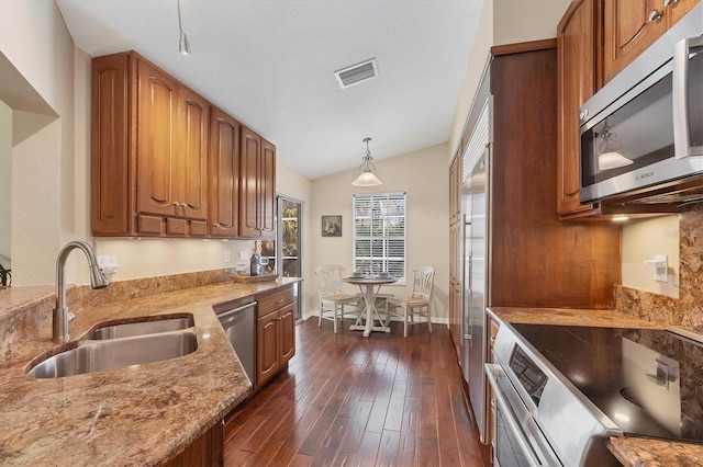 kitchen with brown cabinets, stainless steel appliances, and a sink