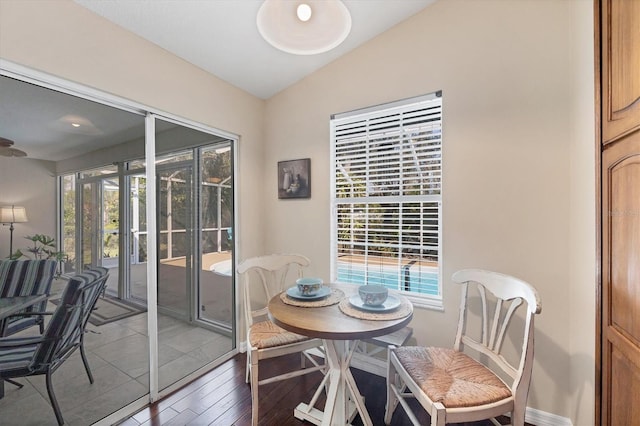 dining space with light wood-style floors, lofted ceiling, and baseboards