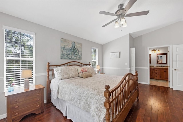 bedroom featuring dark wood-style flooring, vaulted ceiling, baseboards, and ensuite bathroom