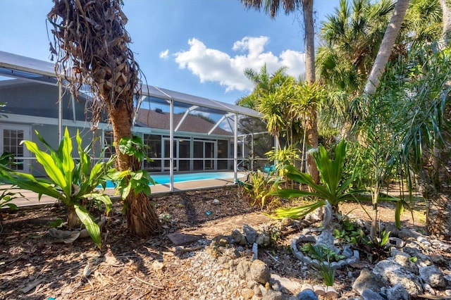 view of yard with glass enclosure and an outdoor pool