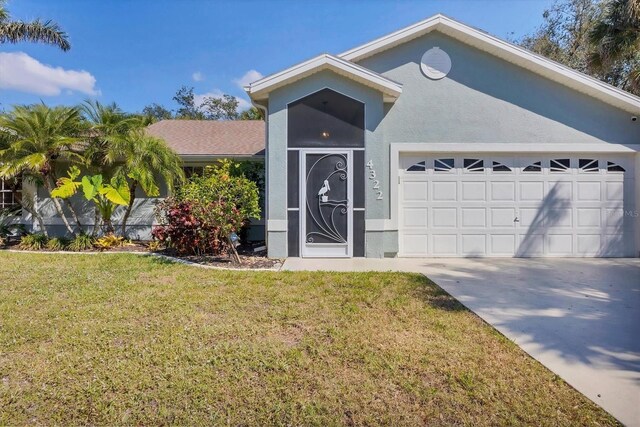 single story home with driveway, a garage, a front yard, and stucco siding