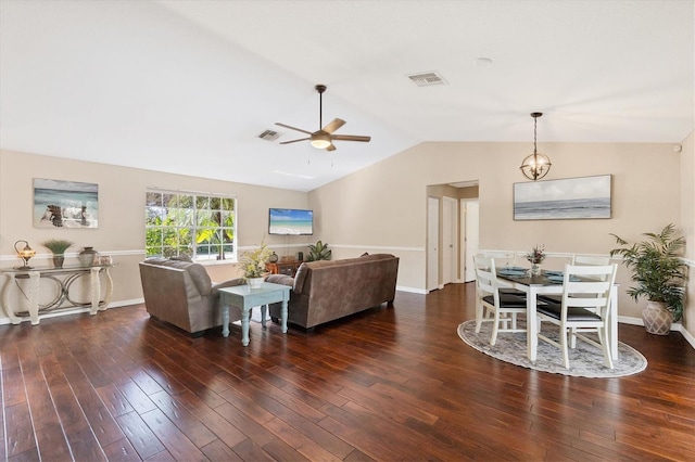 living room with ceiling fan with notable chandelier, lofted ceiling, visible vents, and wood finished floors