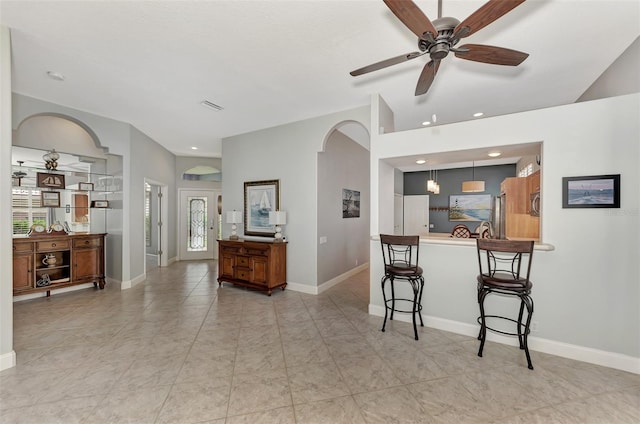 kitchen featuring decorative light fixtures, a breakfast bar, ceiling fan, and kitchen peninsula