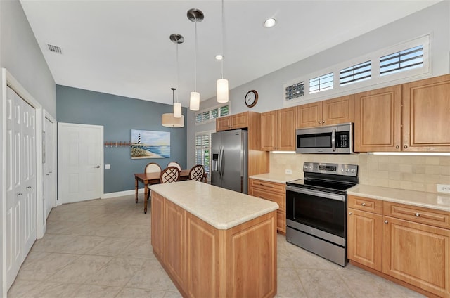 kitchen with a kitchen island, decorative light fixtures, tasteful backsplash, light tile patterned floors, and stainless steel appliances