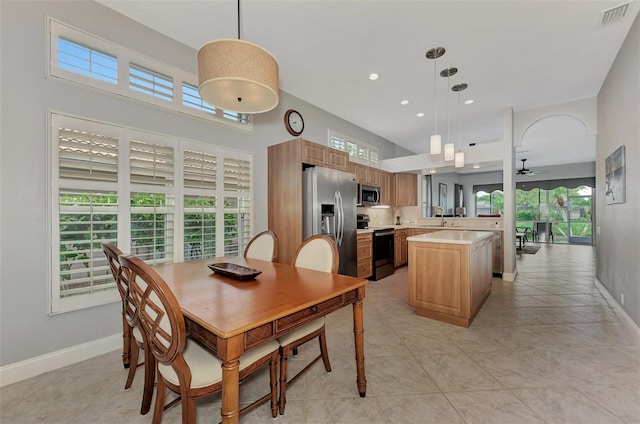 tiled dining room with ceiling fan, sink, and a wealth of natural light