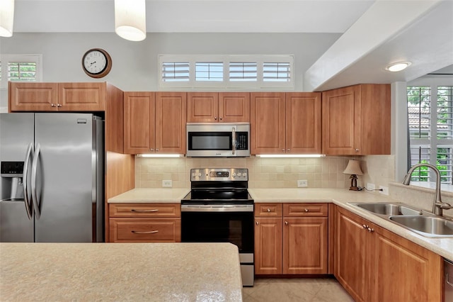 kitchen with stainless steel appliances, tasteful backsplash, sink, and light tile patterned flooring