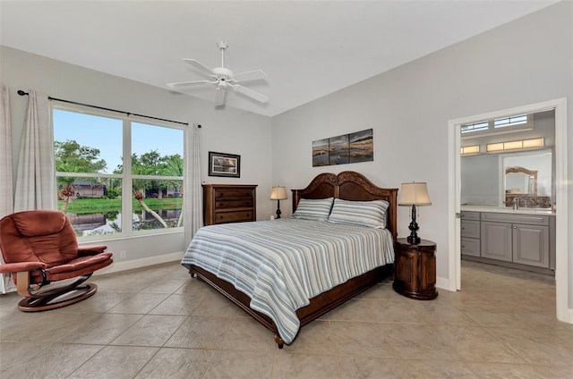 tiled bedroom featuring sink, ceiling fan, and ensuite bath