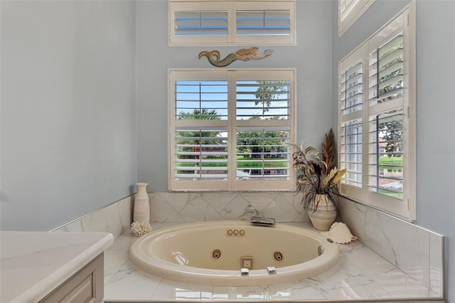 bathroom with vanity and tiled bath