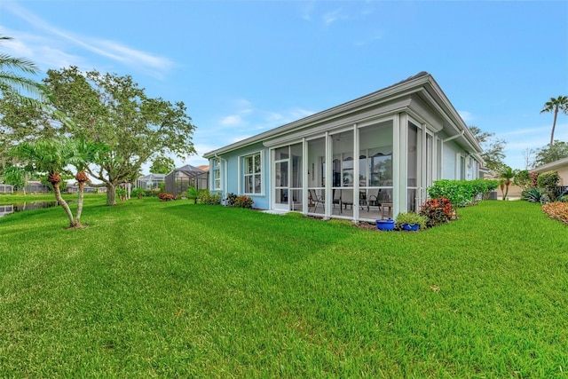 back of property featuring a yard and glass enclosure