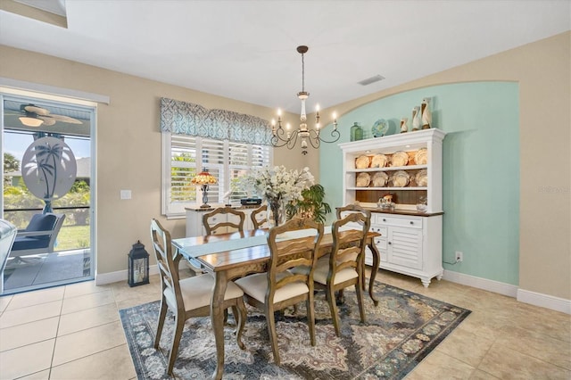 tiled dining room with built in features and a notable chandelier