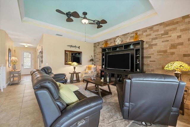 living room featuring ornamental molding, a raised ceiling, and tile patterned flooring