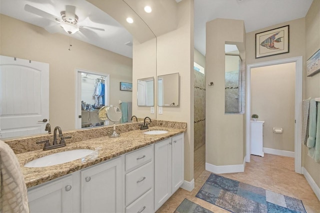 bathroom with a shower, vanity, ceiling fan, and tile patterned flooring