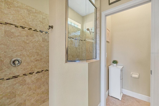 bathroom with tiled shower and tile patterned flooring